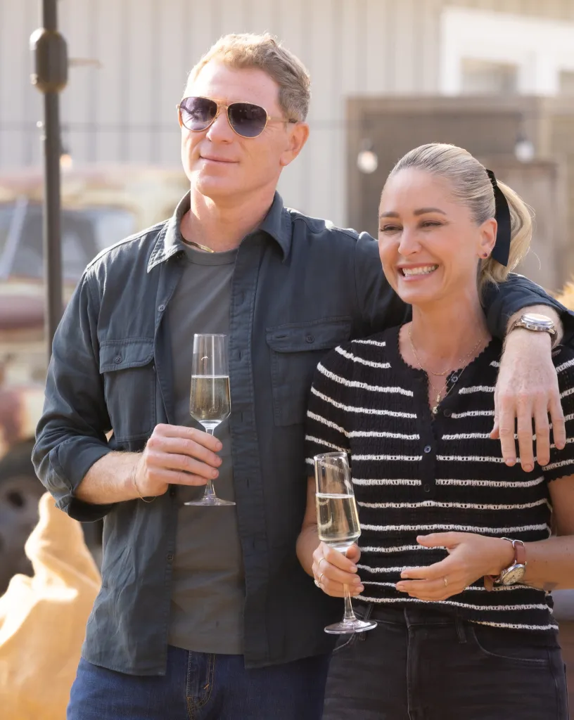 Bobby Flay and Brooke Williamson clinking champagne glasses.