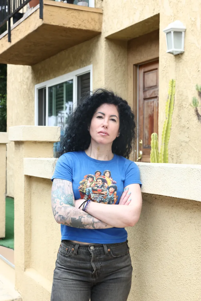 Nikki Dobrin, whose home insurance policy was cancelled, poses at her condo.