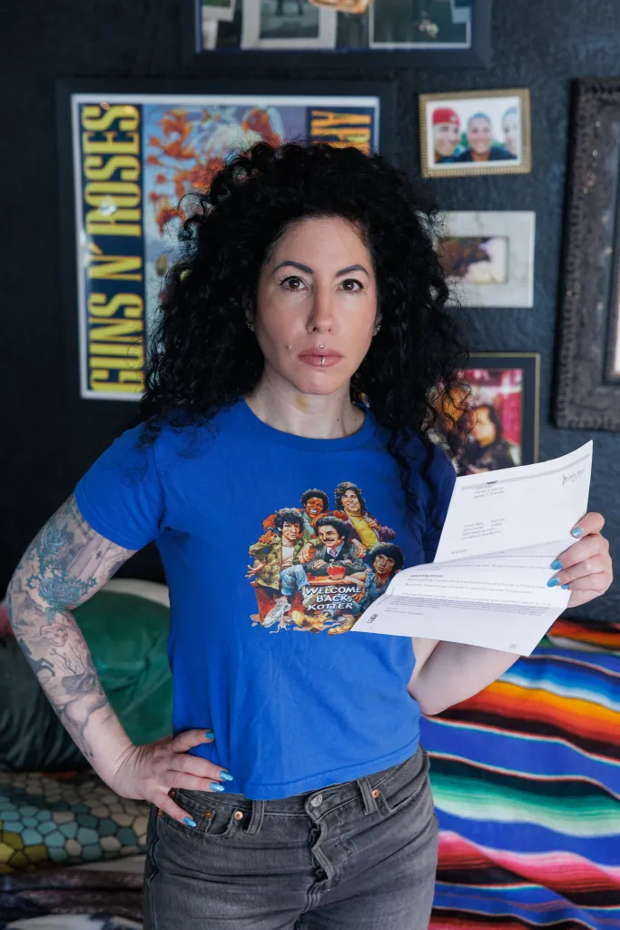 Nikki Dobrin holding a letter canceling her home insurance policy.