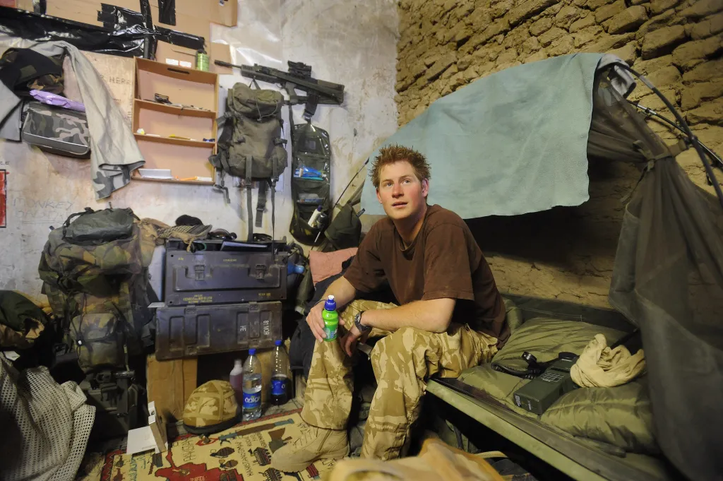 Prince Harry sits on his camp bed in his accommodation in Afghanistan.
