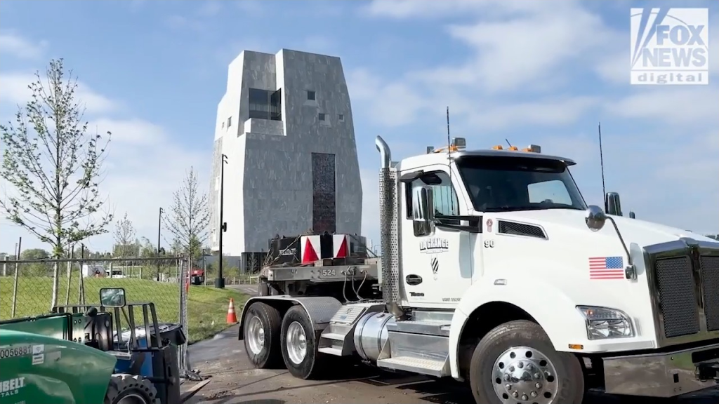 A semi-truck with an American flag decal on its hood is parked in front of the Obama Presidential Center in Chicago.