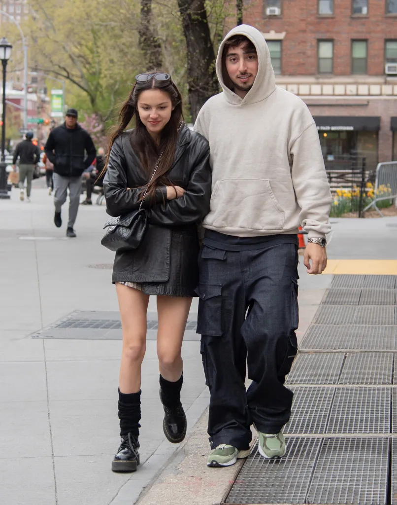 Olivia Rodrigo and Zack Bia walking together outdoors.