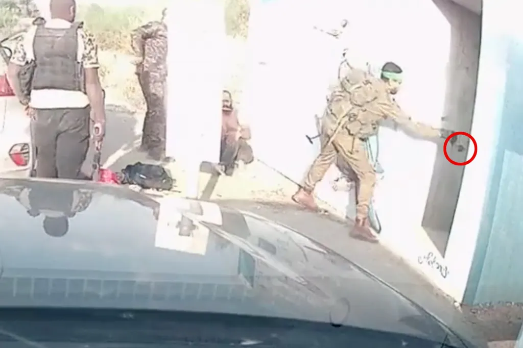 Still image from a video showing a Hamas terrorist throwing a grenade at the field shelter where attendees of the Supernova desert rave were attempting to hide.