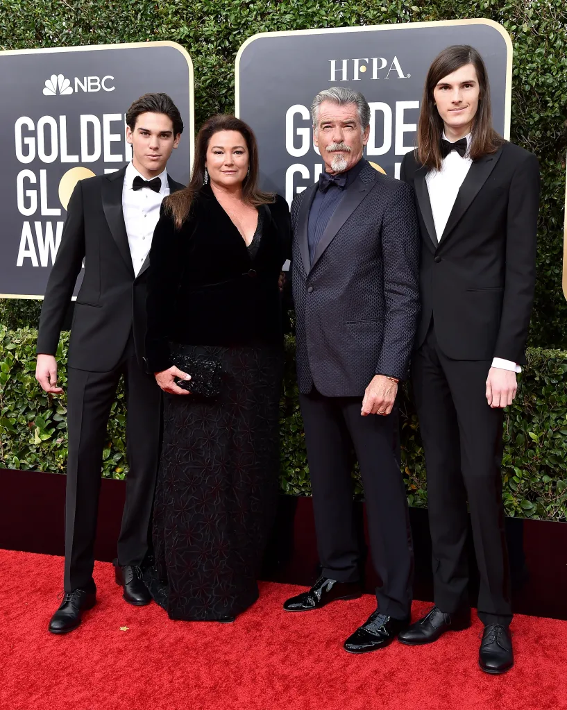 Paris Brosnan, Keely Shaye Smith, Pierce Brosnan, and Dylan Brosnan standing on a red carpet in front of a Golden Globe Awards backdrop.