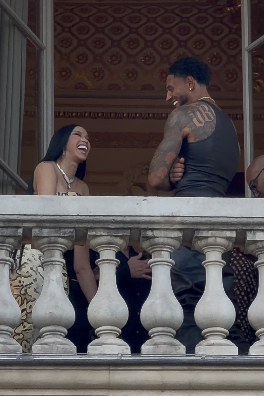 Cardi B and Maduka Okoye laughing together on a terrace in Paris.