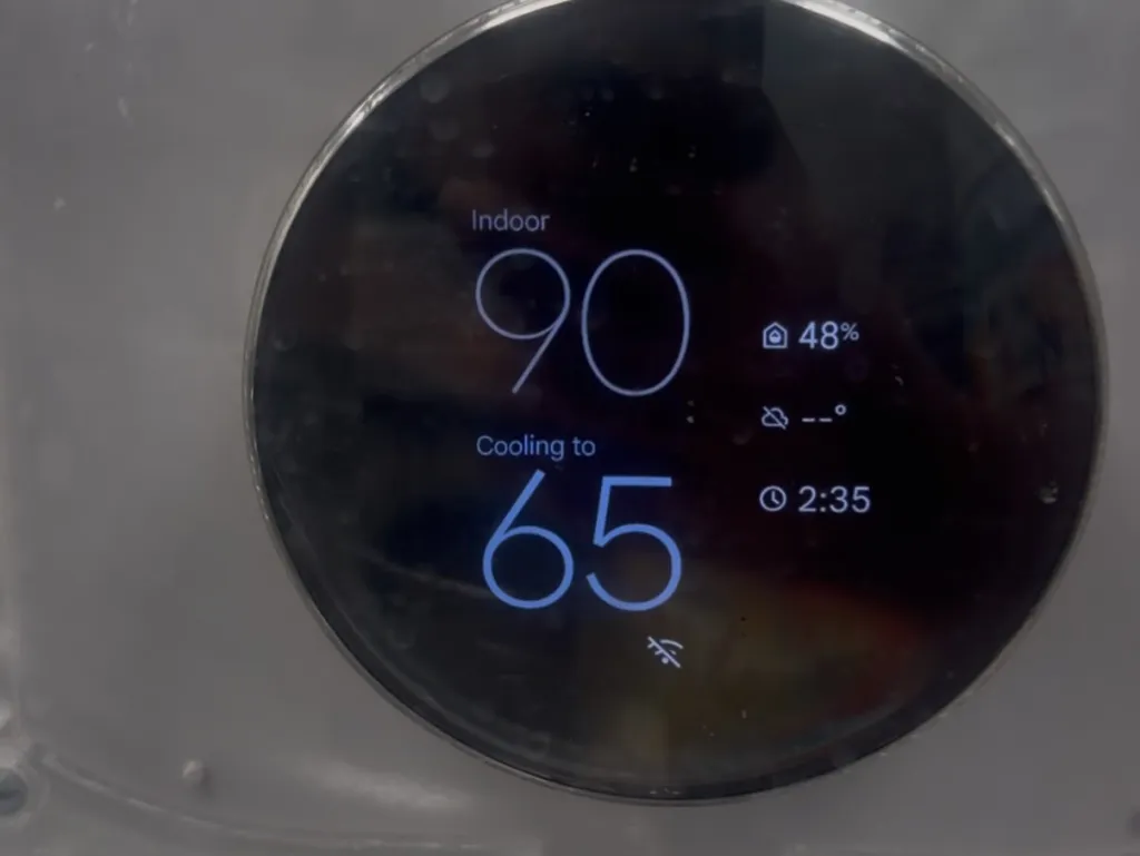 A smart thermostat display showing an indoor temperature of 90 degrees and "Cooling to 65," with an icon indicating no AC.
