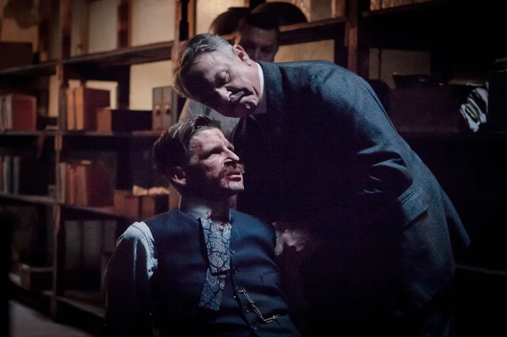 Paul Anderson as Arthur Shelby, bleeding and being held by Sam Neill as Inspector Campbell in Peaky Blinders.