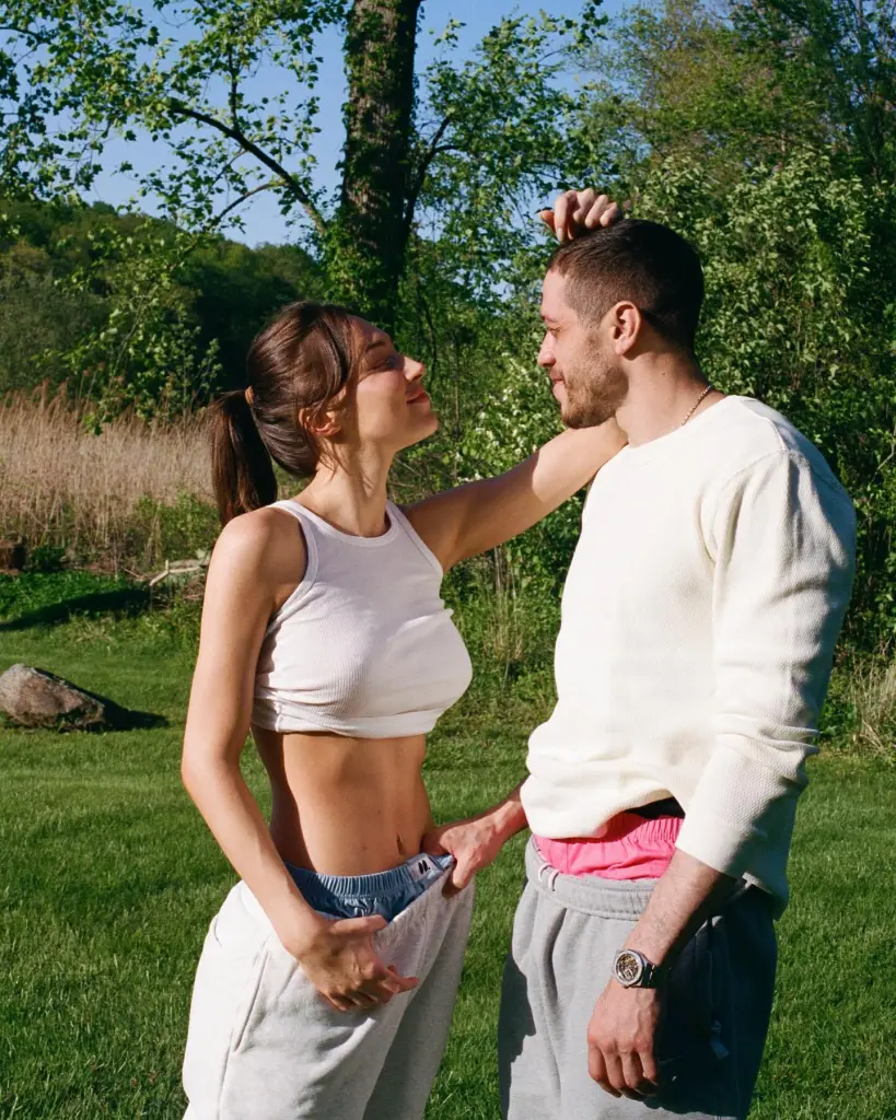 Pete Davidson and Elsie Hewitt looking at each other in a grassy field.