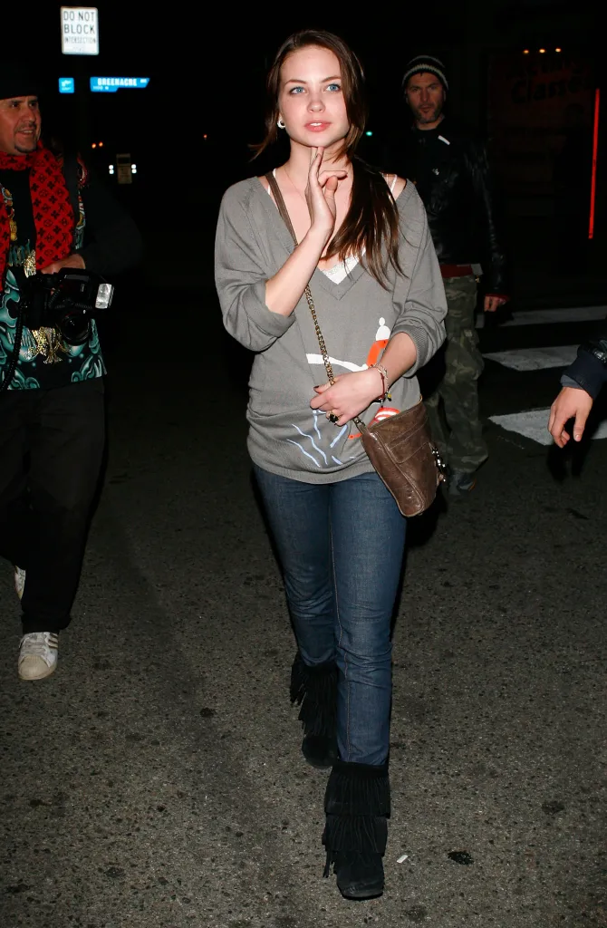 Daveigh Chase walking on a street at night.