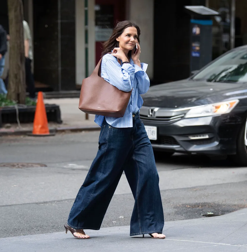 Katie Holmes walking and talking on a phone, carrying a Cuyana bag.