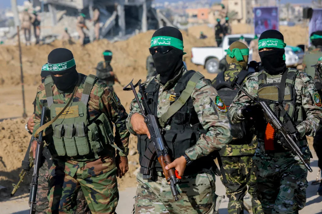Hamas fighters in camouflage and balaclavas, holding rifles, gather in Gaza.