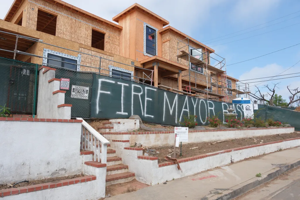 Graffiti on a construction site fence in Pacific Palisades reads "Fire Mayor Bass" and "They Let Us Burn".