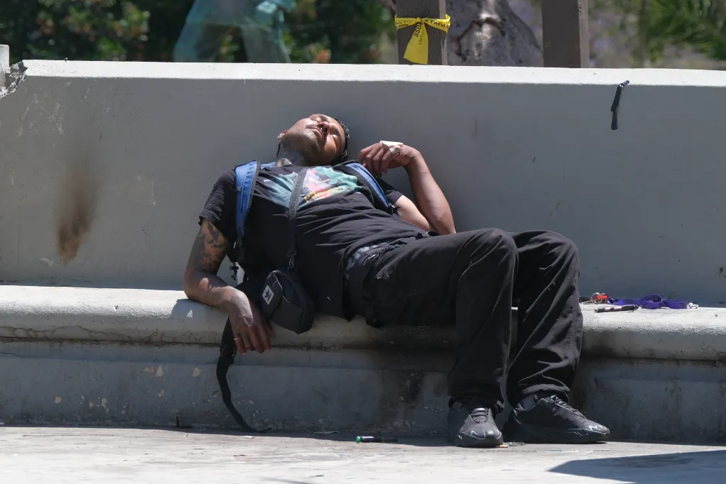 A man lies back against a concrete wall in Macarthur Park the day after a federal anti-drug operation.