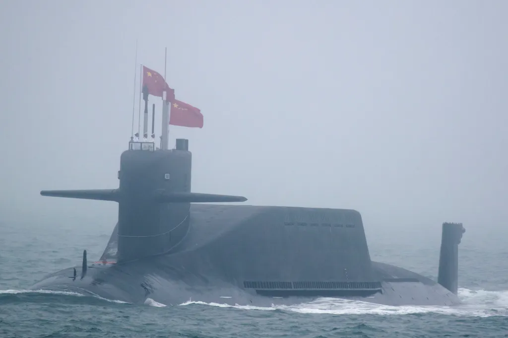 A Type 094A Jin-class nuclear submarine of the PLA Navy with Chinese flags flying from its conning tower.