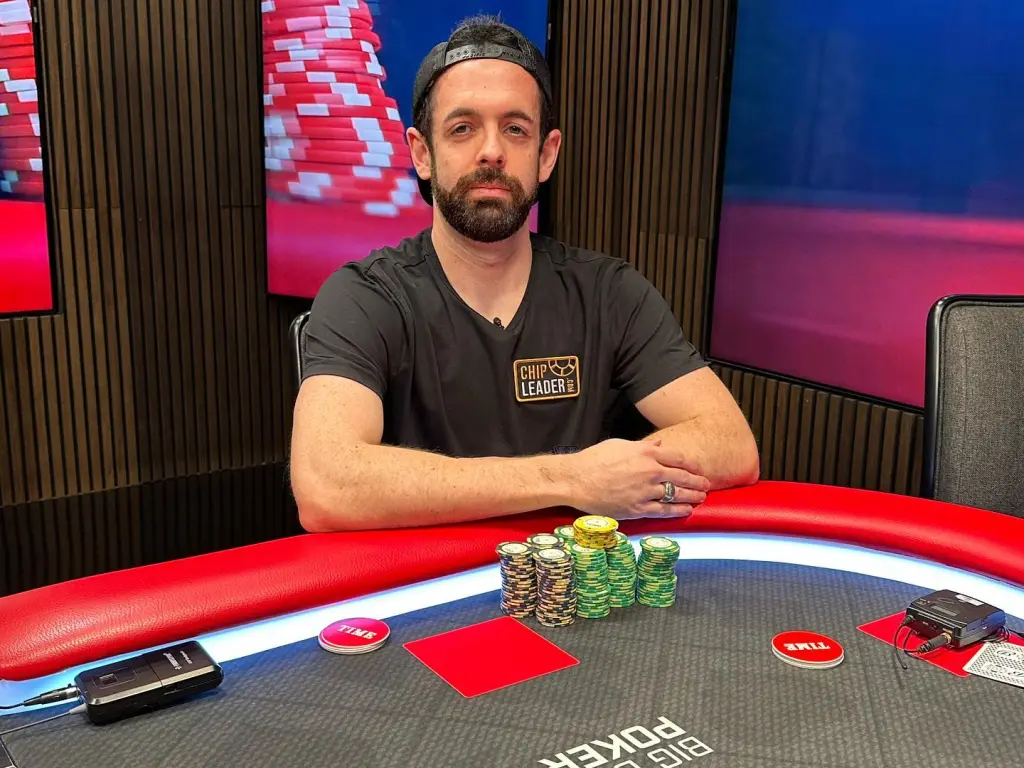 Poker player Jared Griener sitting at a poker table with stacks of chips.