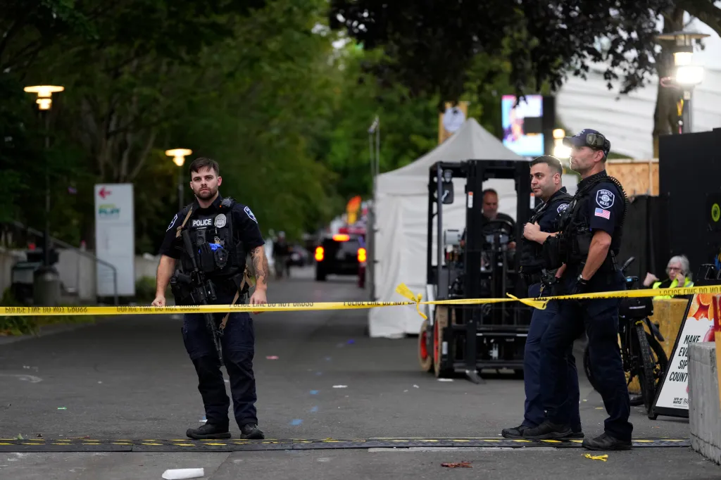 Police officers standing behind "POLICE DO NOT CROSS" tape at the Bite of Seattle festival.