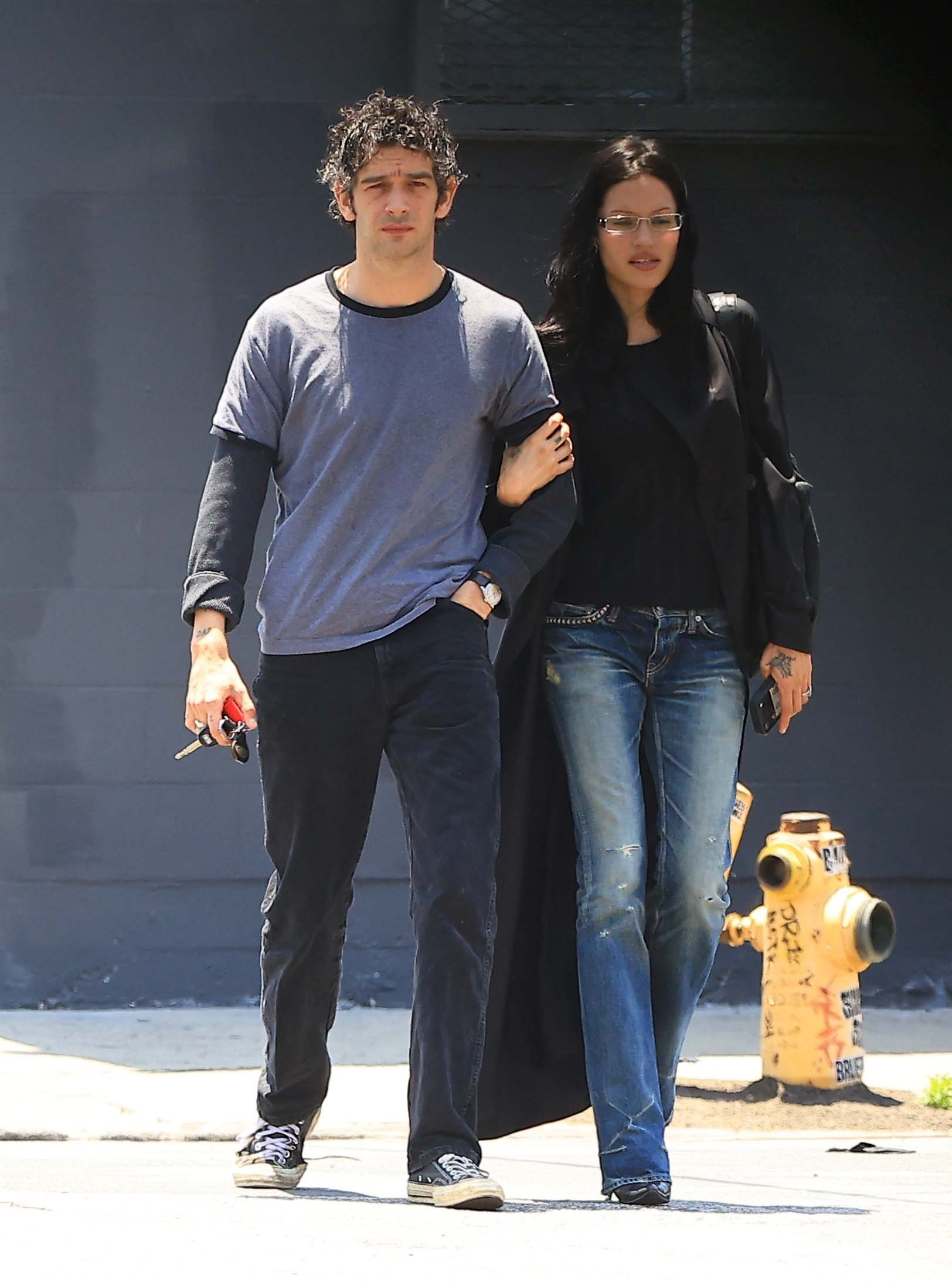 Matty Healy and Gabbriette Bechtel walking with arms linked.