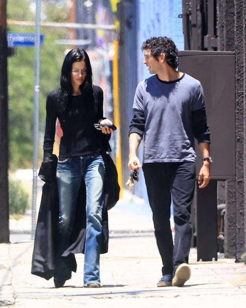Matty Healy and Gabbriette Bechtel walking down a street.