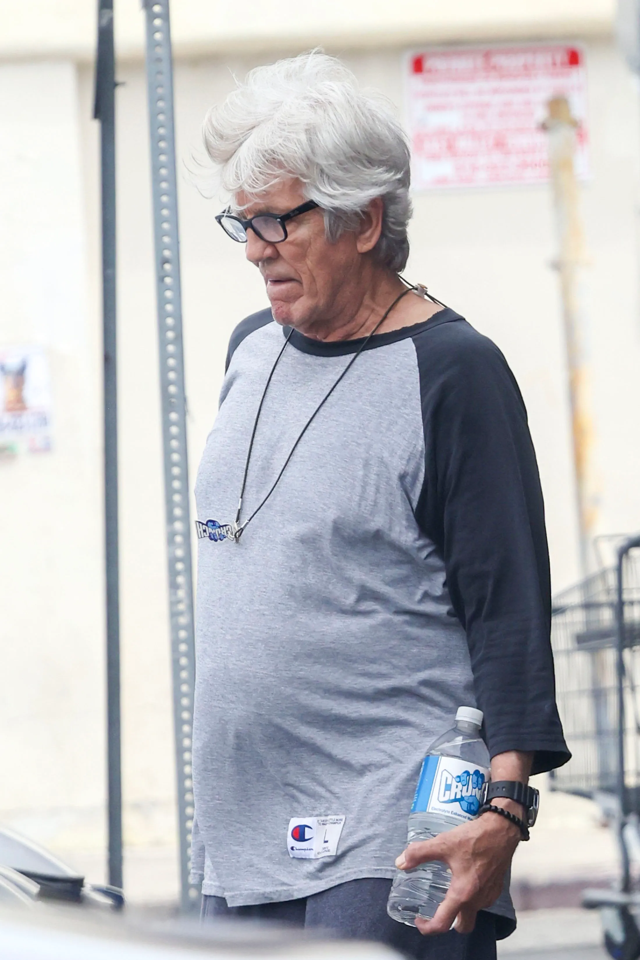 Eric Roberts leaving Crunch Gym holding a water bottle.