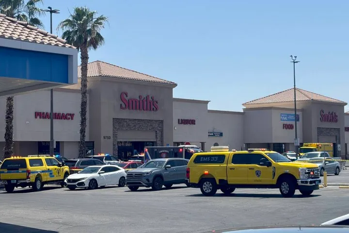 Emergency vehicles and police cars gathered in front of a Smith's grocery store.