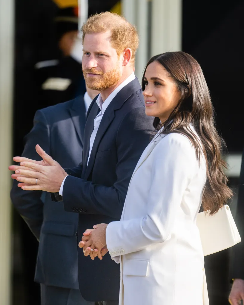 Prince Harry, Duke of Sussex, and Meghan, Duchess of Sussex, standing and clapping.