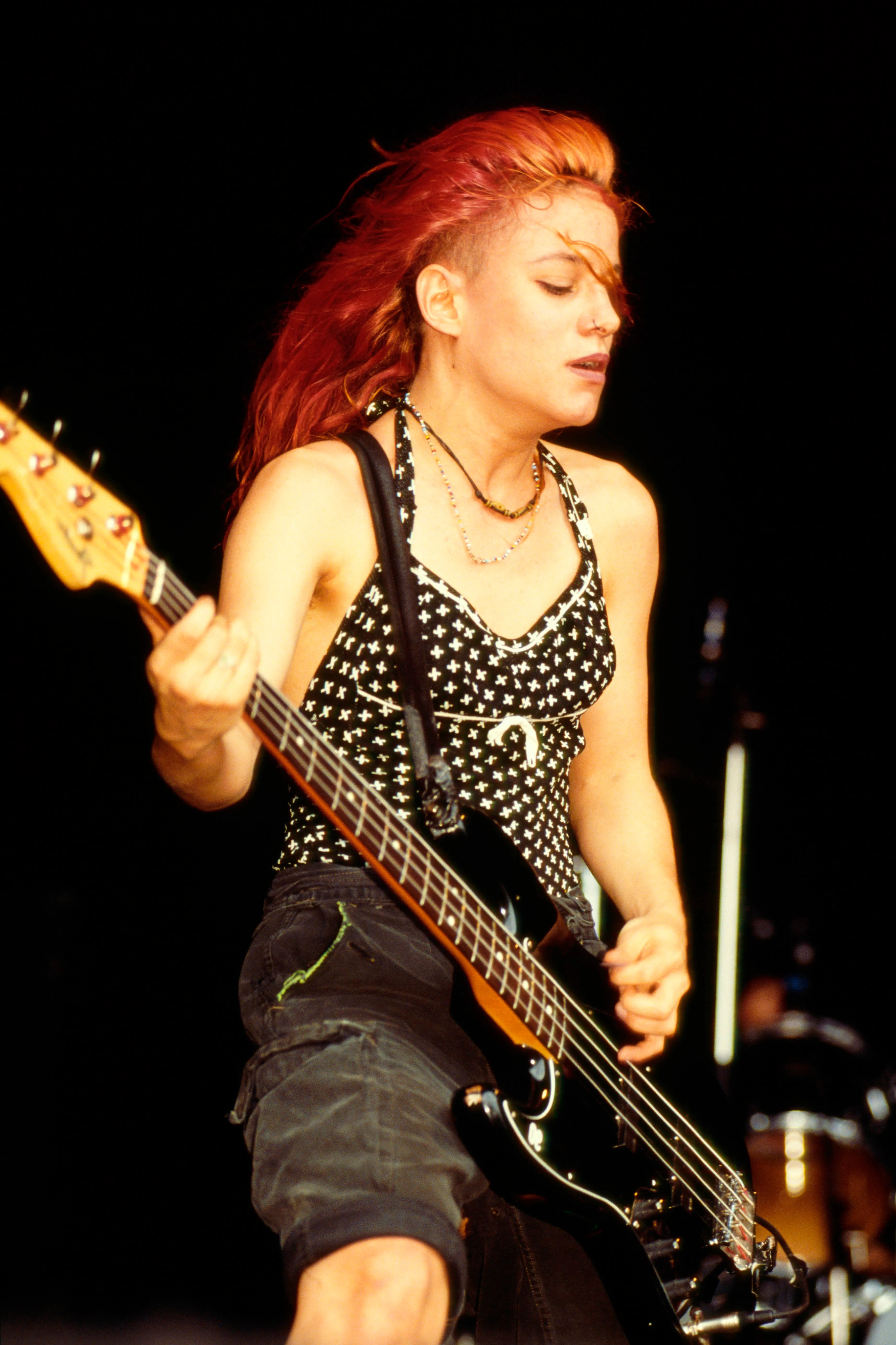 Jennifer Finch performing bass guitar on stage.