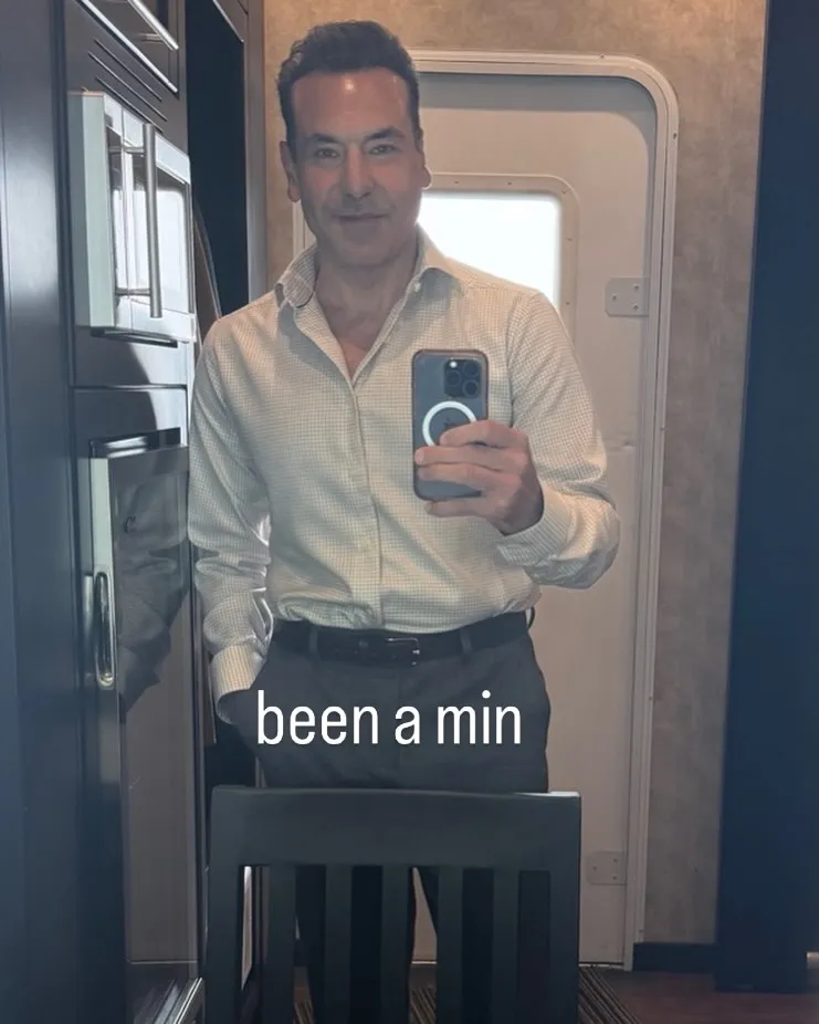 Rick Hoffman posing for a mirror selfie in a casual outfit.