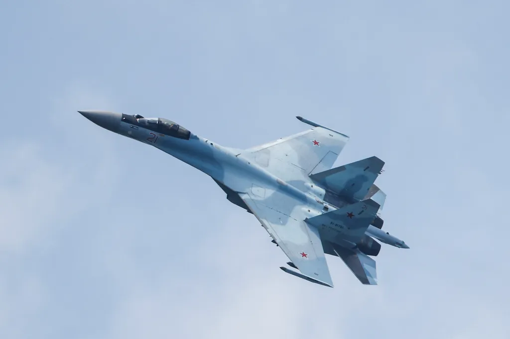 Russian Sukhoi Su-35S jet fighter against a light blue sky.