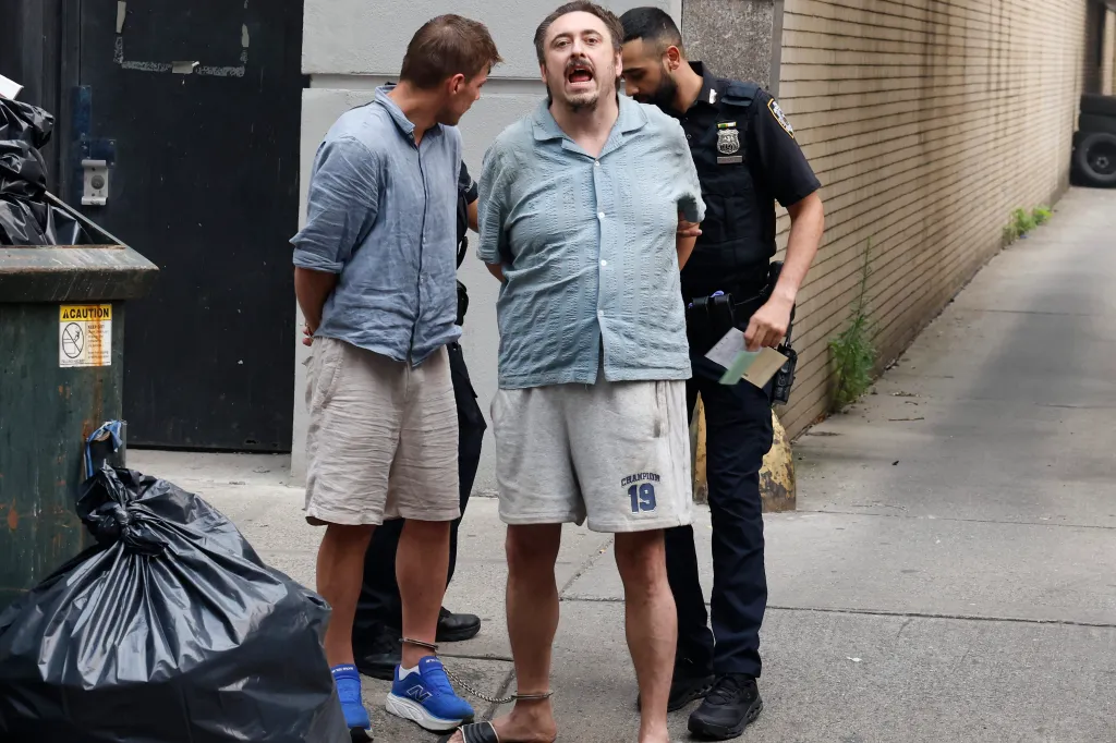Andrew Truelove, an arrestee, standing with two NYPD officers, one of whom is handcuffing him.