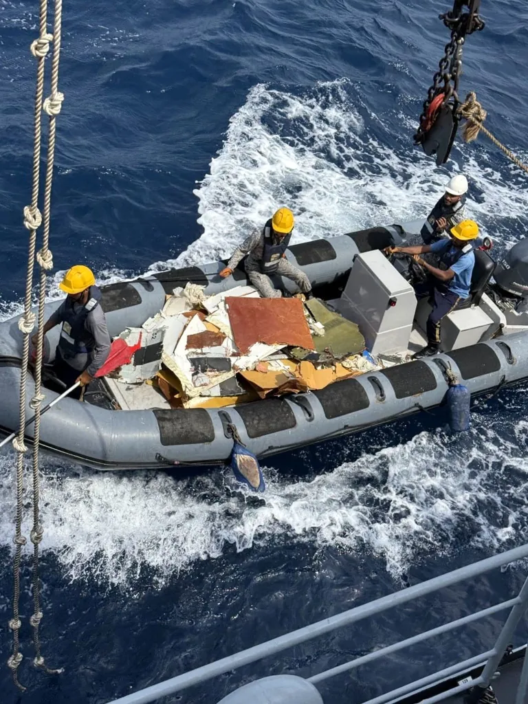 Pakistan Navy personnel in a dinghy boat recovering wreckage of a K2 Airways cargo Boeing 737 aircraft.