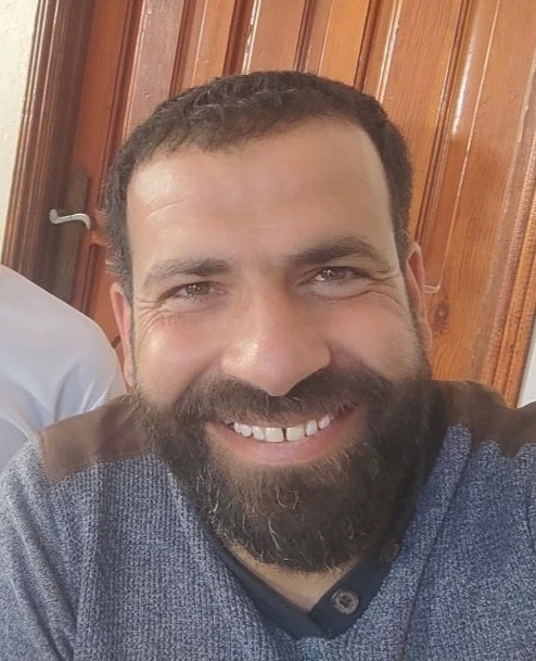 A man with a beard smiles at the camera.