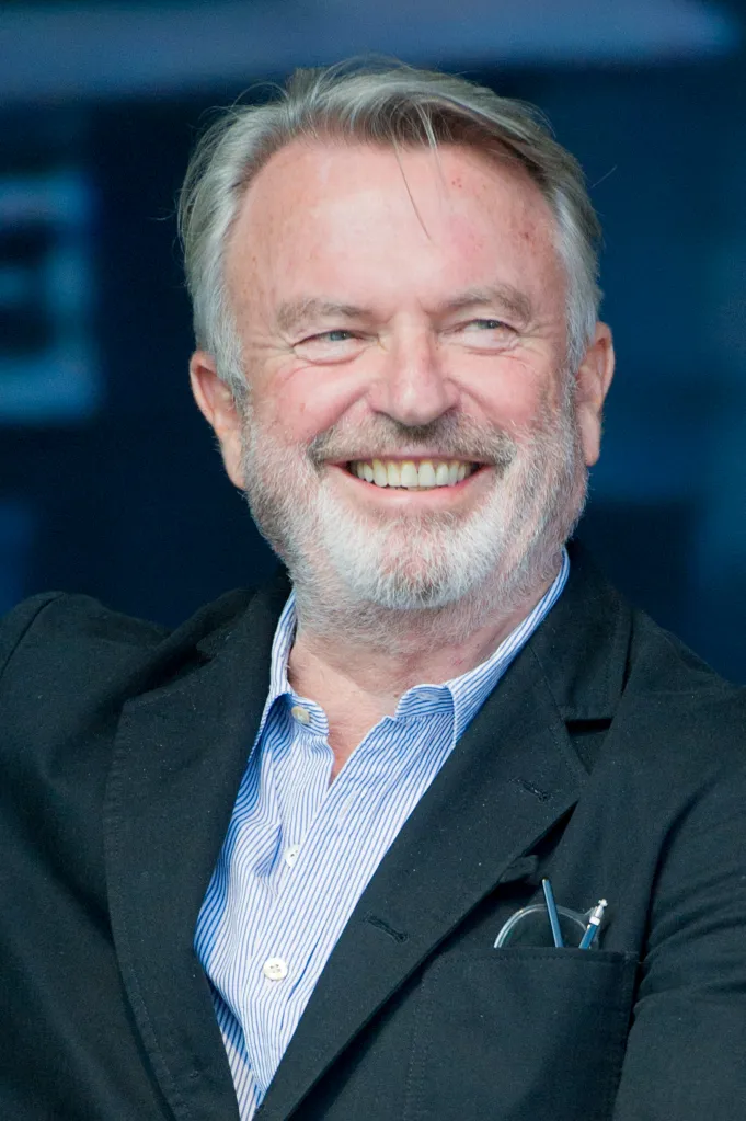 Sam Neill smiling during a Q&A session.