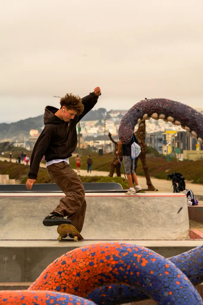 A young man skateboarding at Sunset Dunes park.