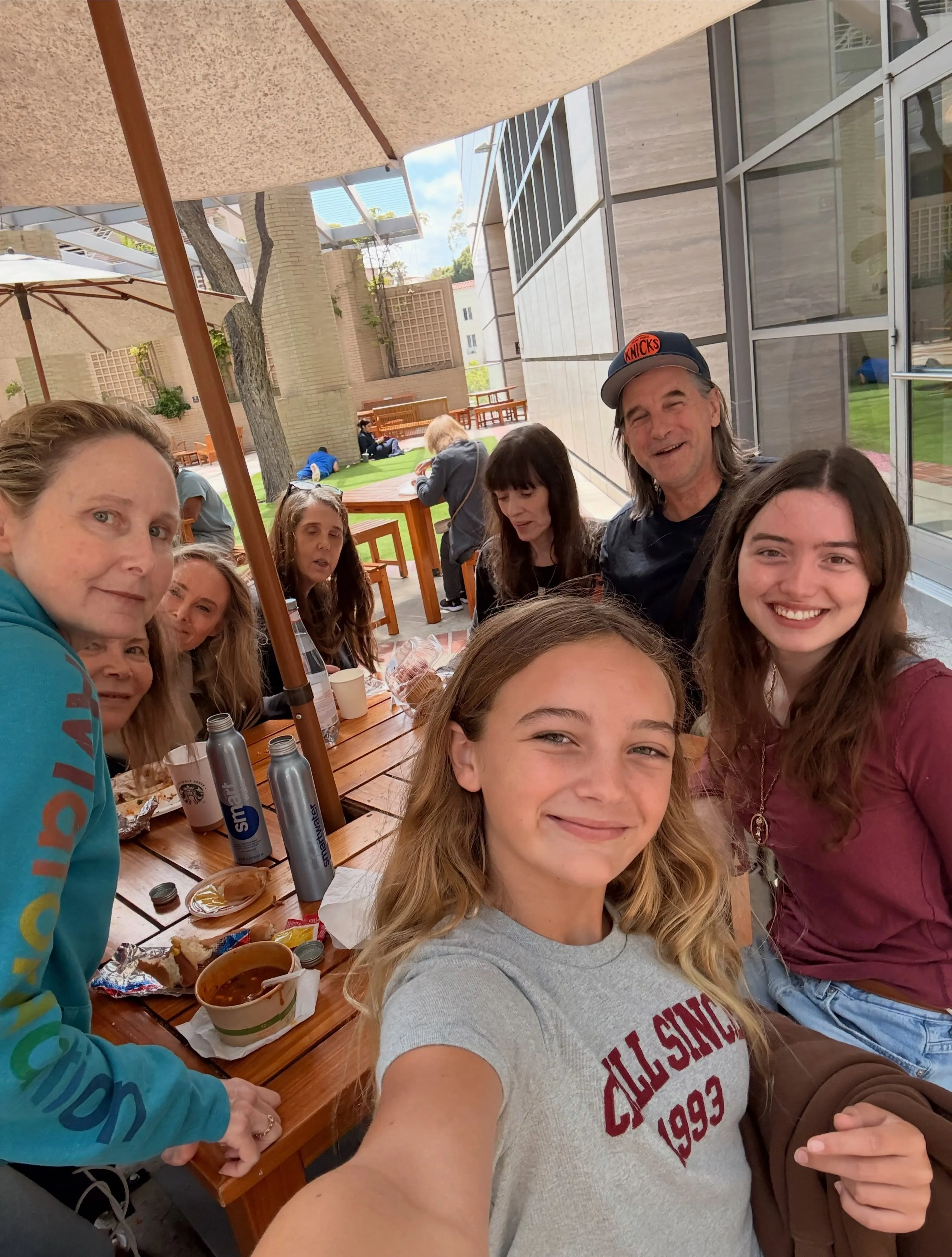 Bijou Phillips with family and friends at an outdoor restaurant.