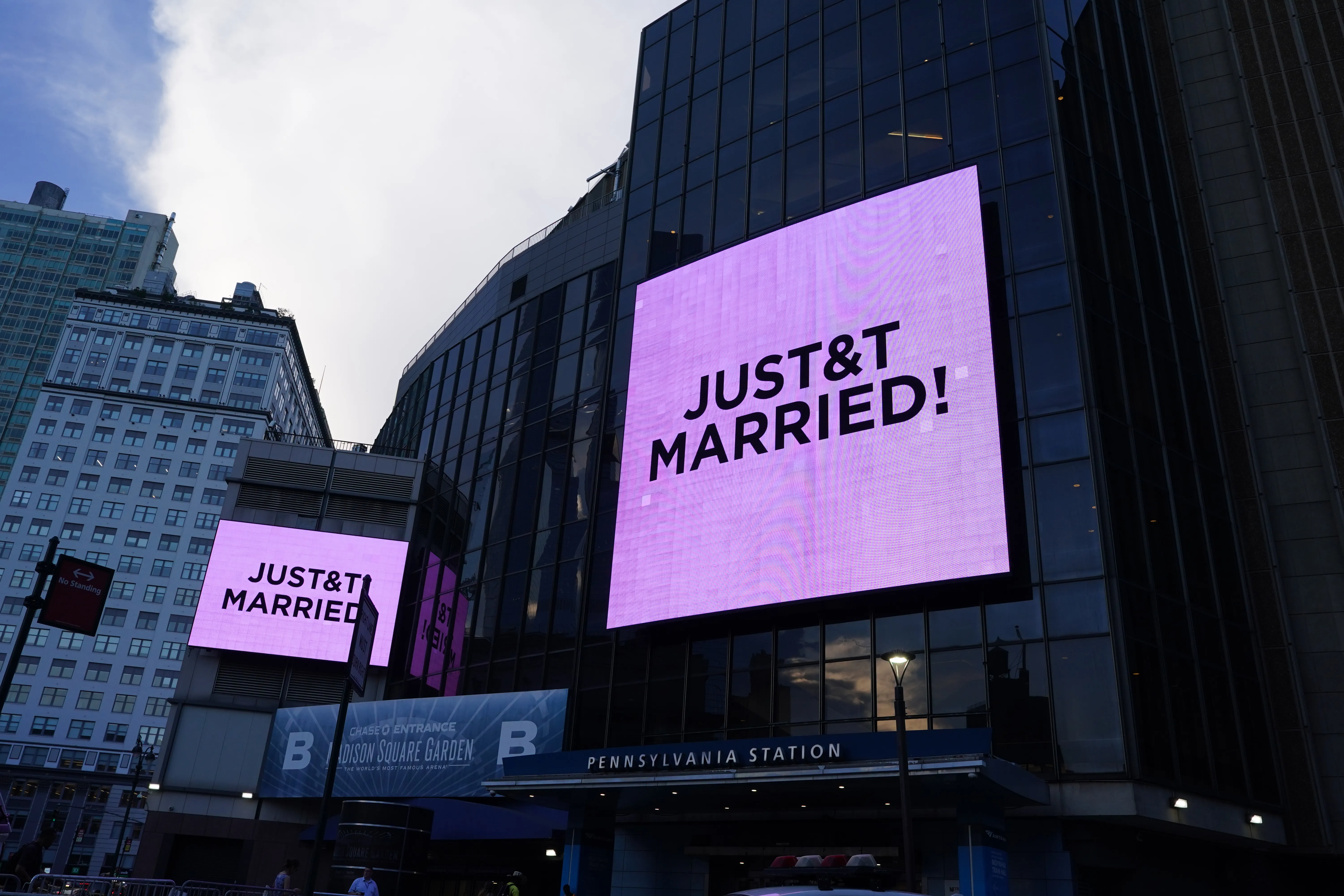 Two large outdoor screens on Madison Square Garden display the text "JUST & T MARRIED!"