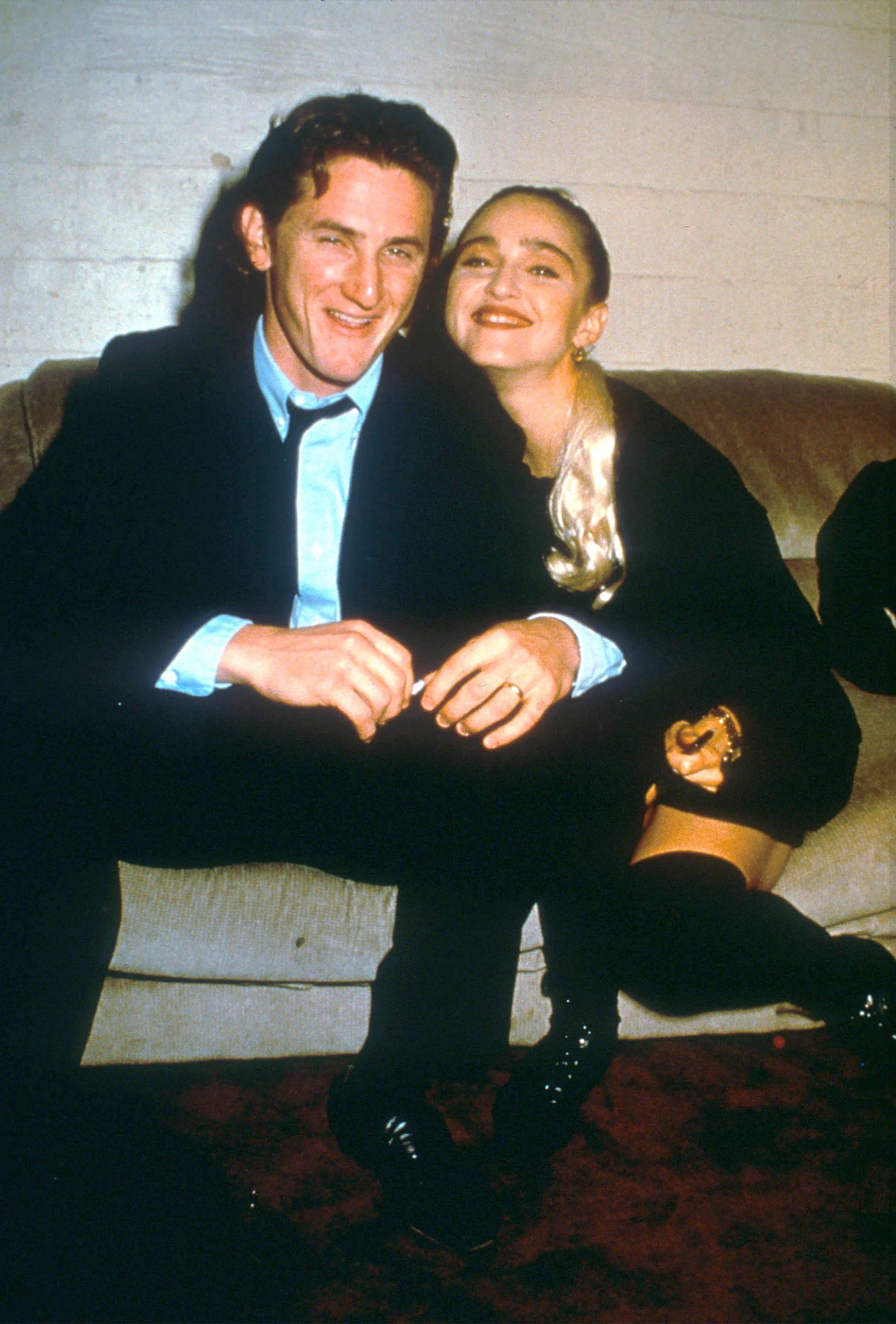 Sean Penn and Madonna smiling and relaxing at an AIDS benefit.