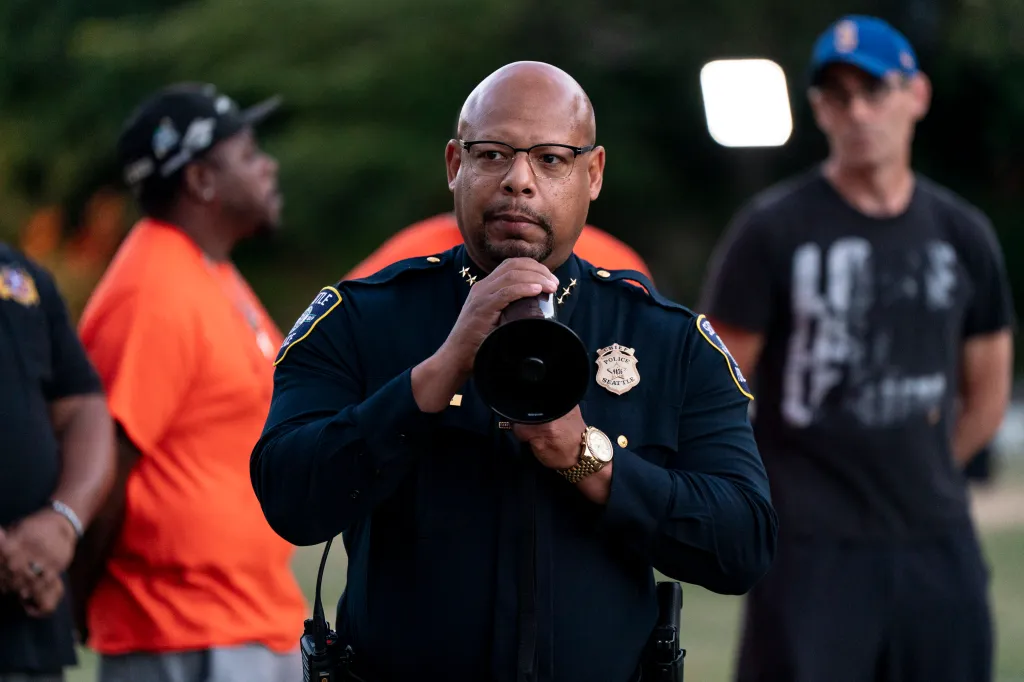 Seattle Police Chief Shon Barnes speaks through a megaphone at a vigil.
