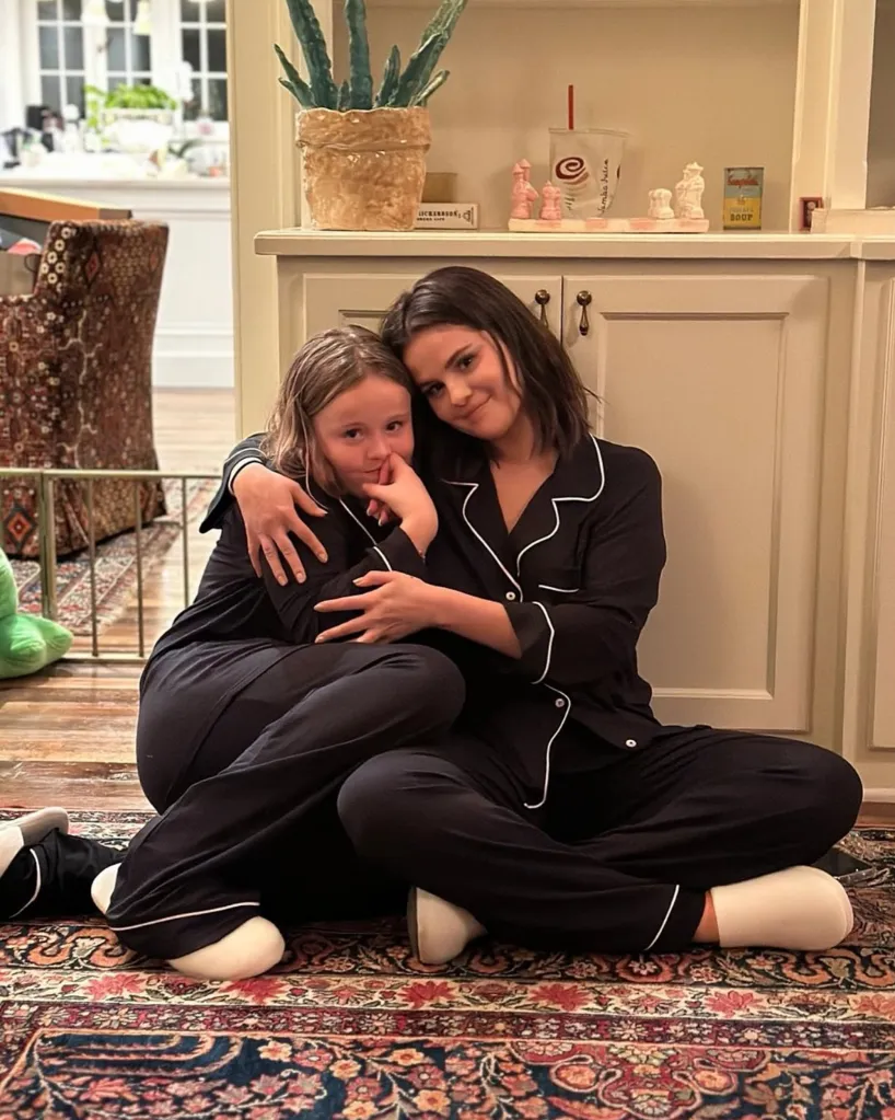 Selena Gomez and her sister Gracie Elliott Teefey in matching pajamas, sitting on a patterned rug.