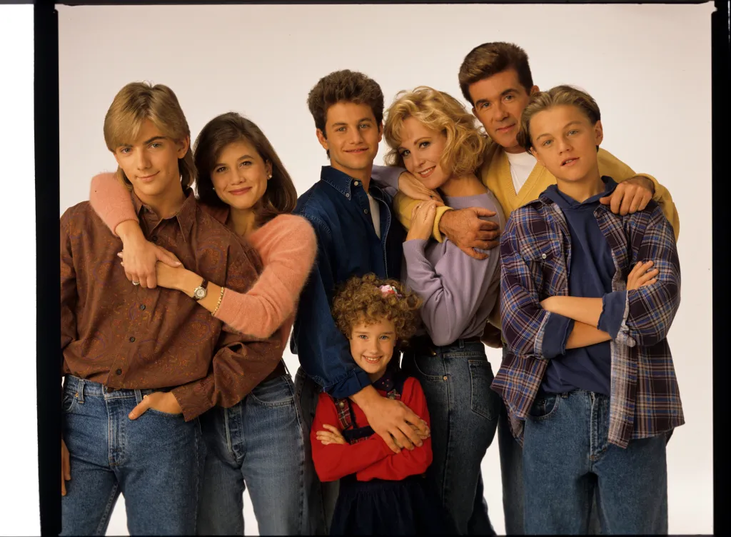 Photo of the cast of the TV show Growing Pains, from left to right: Jeremy Miller, Tracey Gold, Kirk Cameron, Ashley Johnson, Joanna Kerns, Alan Thicke, and Leonardo DiCaprio.