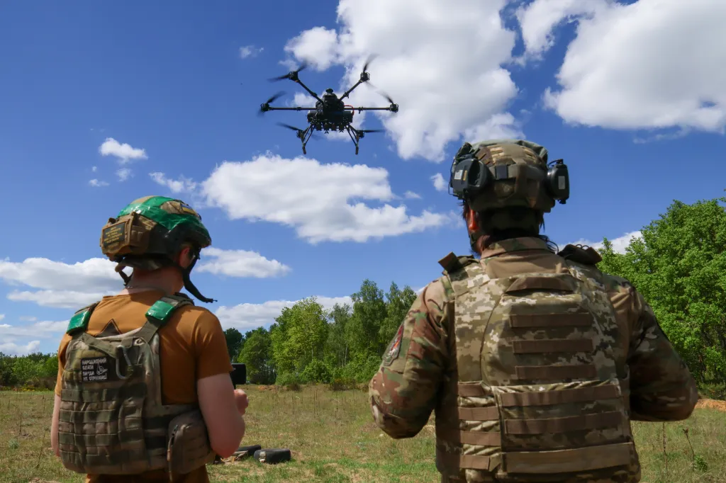 Two servicemen observe a large drone during flight training at the Rarog training center.