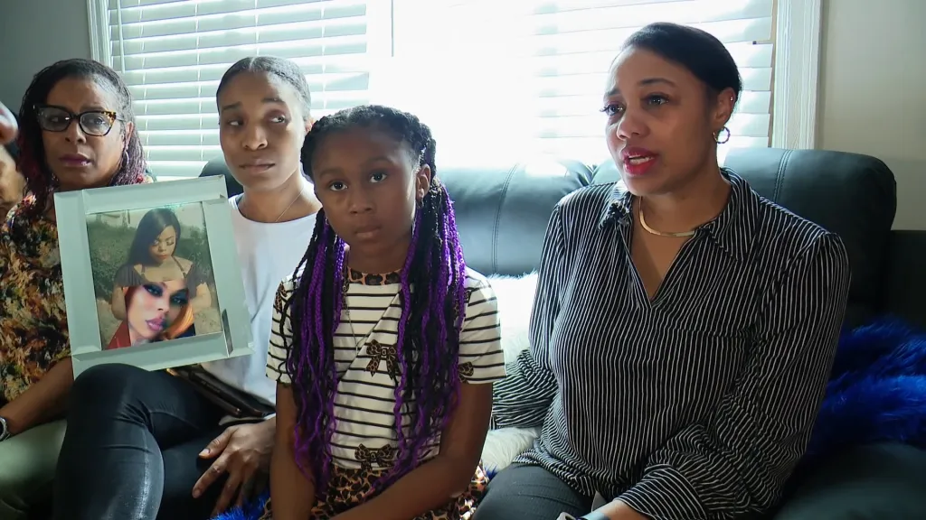 Shakeela Martin's family members, including her children, hold a photo of her.