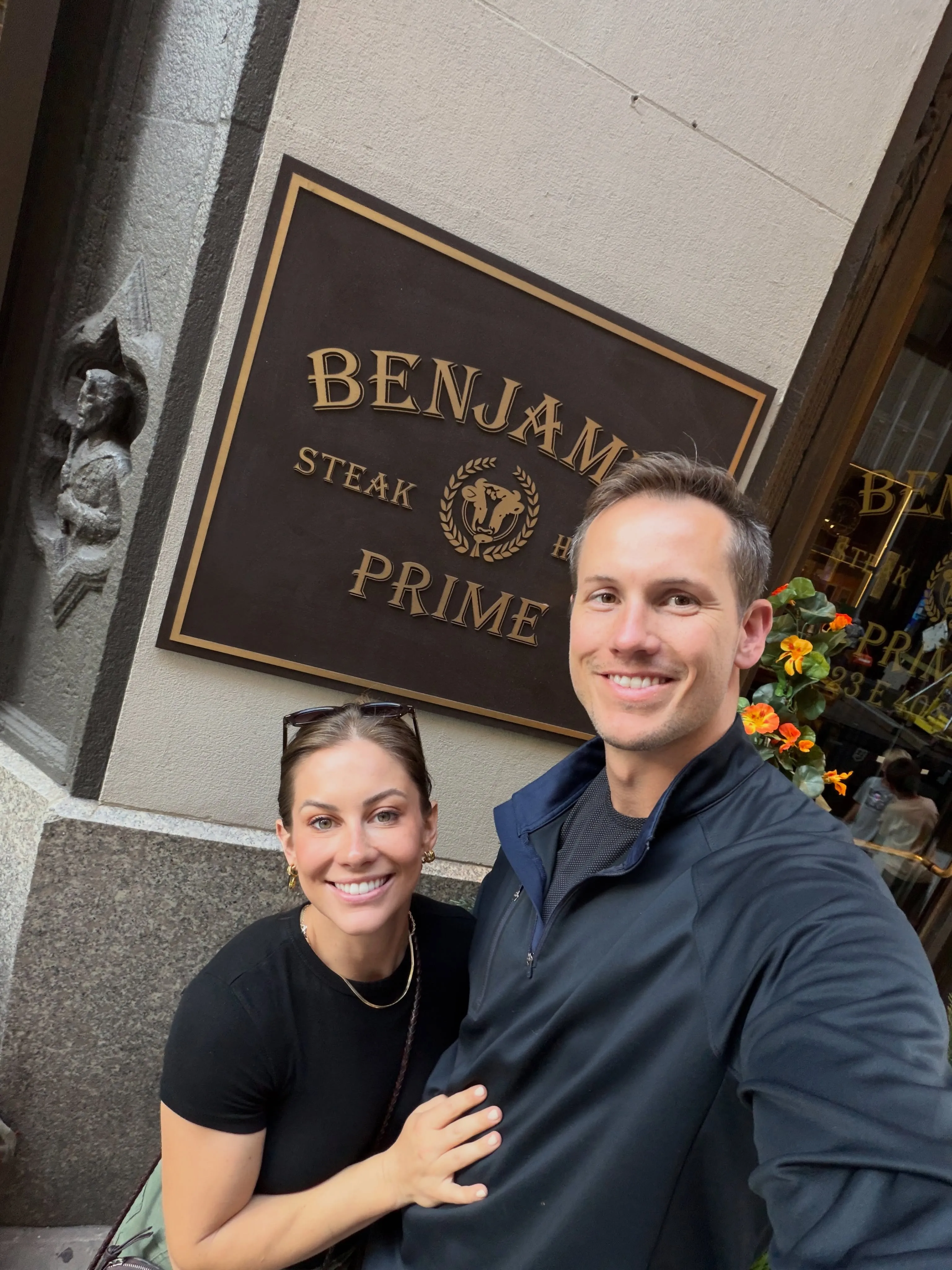 Shawn Johnson and Andrew East smile in front of Benjamin Steakhouse.