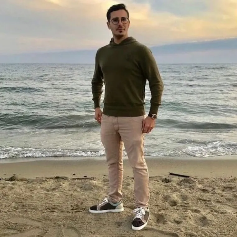 Simon Leviev, "The Tinder Swindler," standing on a beach.