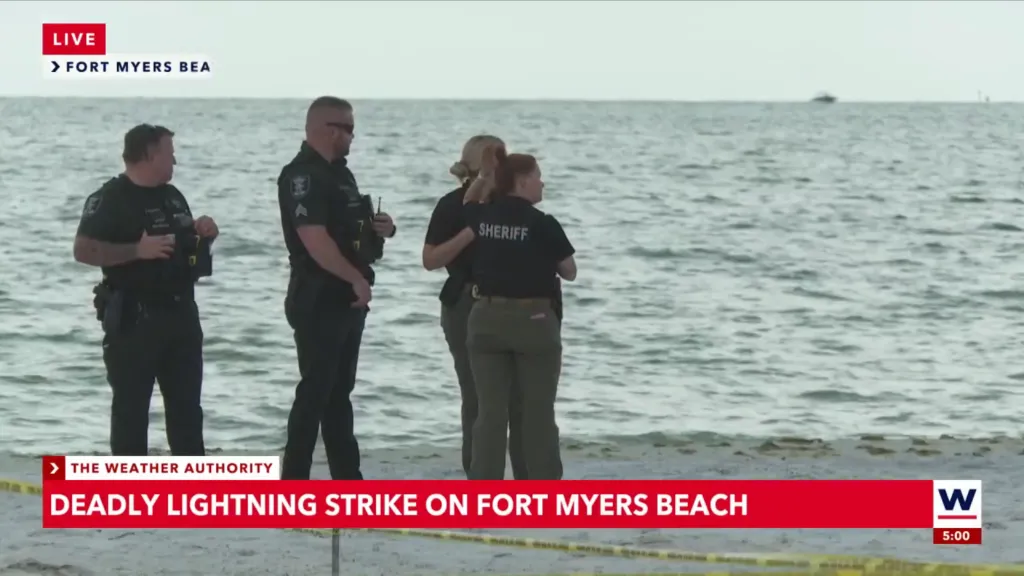 Sheriff's deputies standing on a beach next to the ocean where a deadly lightning strike occurred.