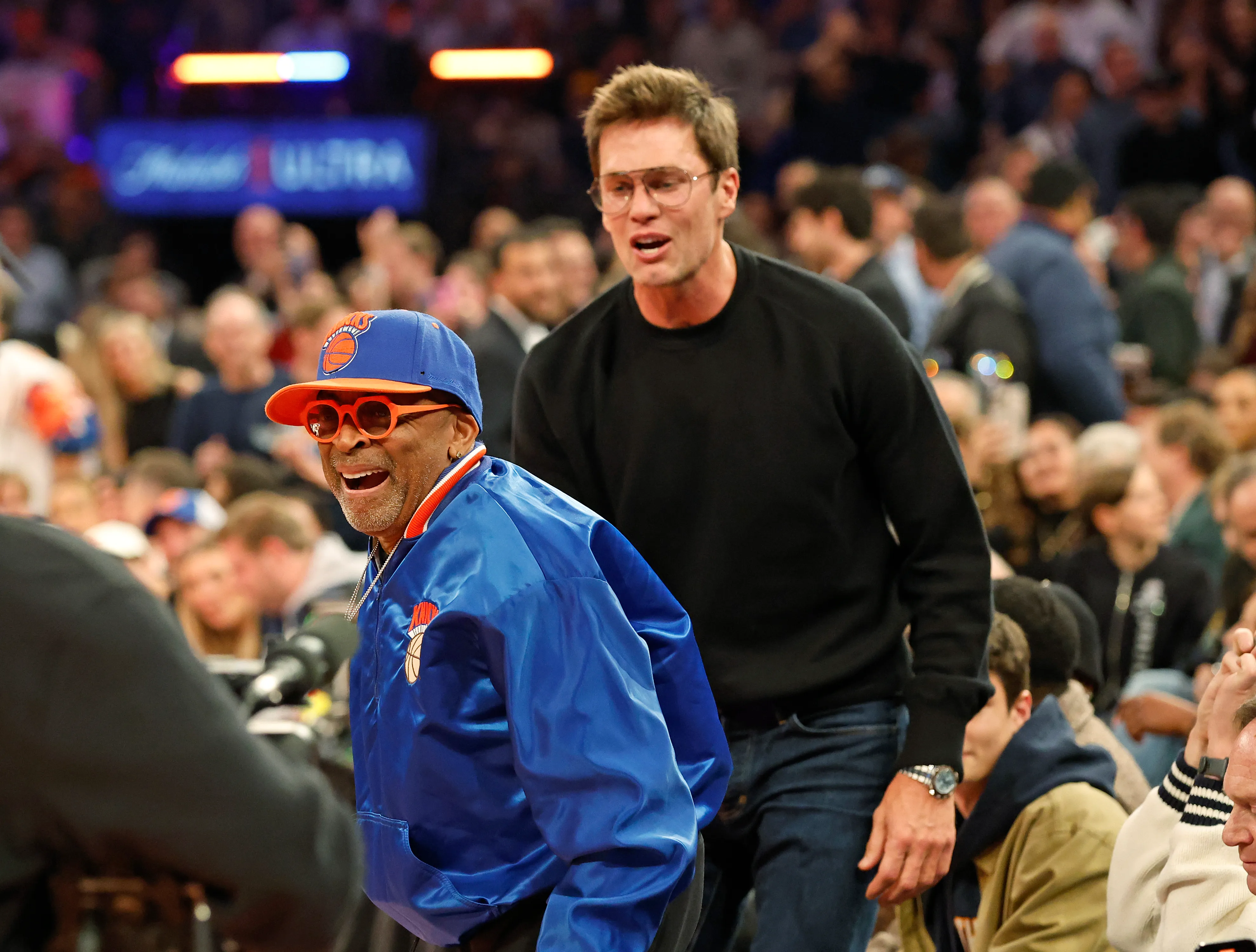 Spike Lee reacts after Tom Brady throws a football into the stands during a New York Knicks game.