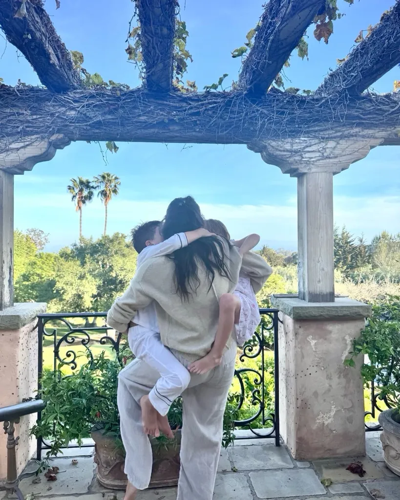 Meghan Markle hugging Archie and Lilibet on a balcony.