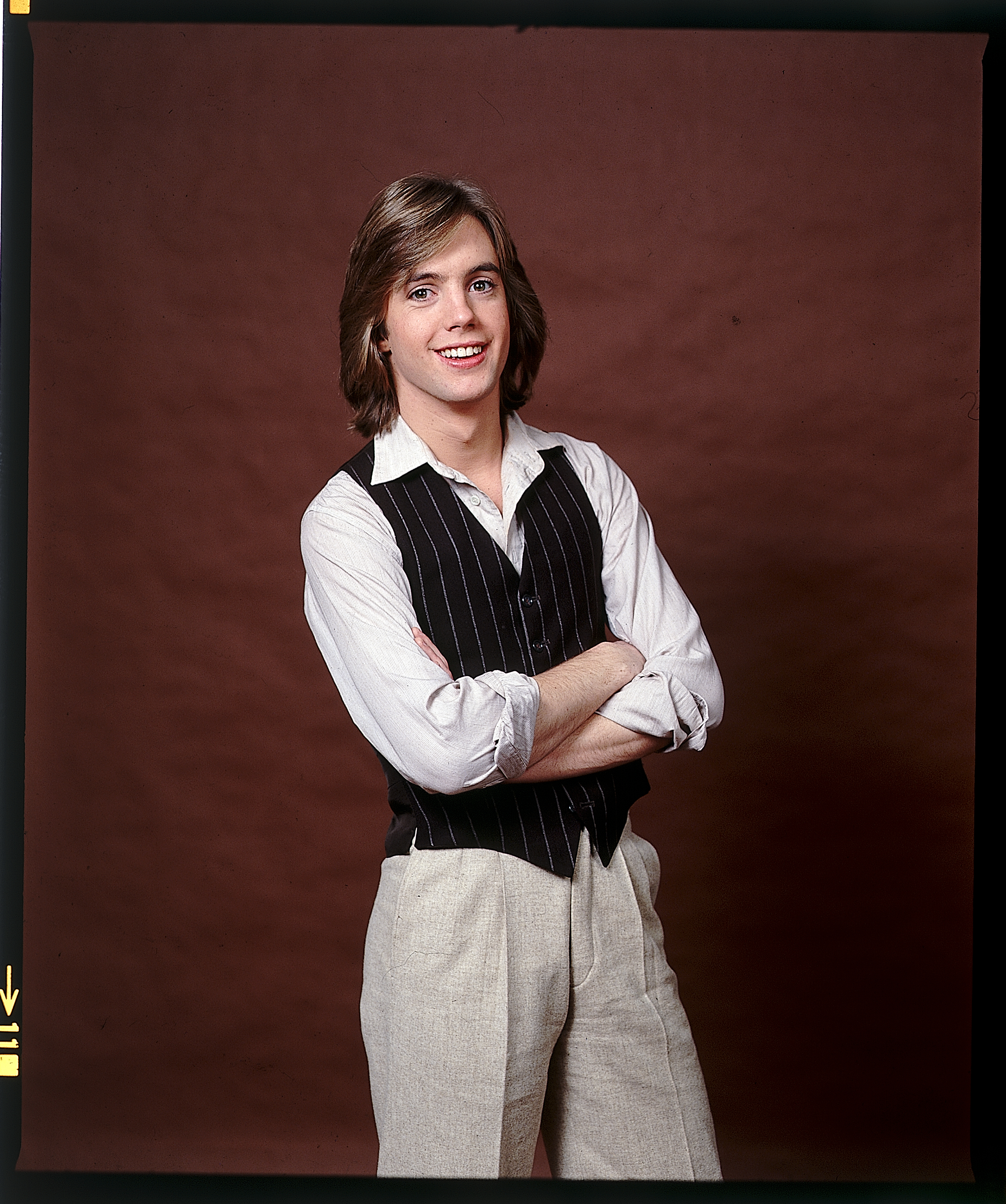 Studio portrait of Shaun Cassidy posing with his arms crossed.