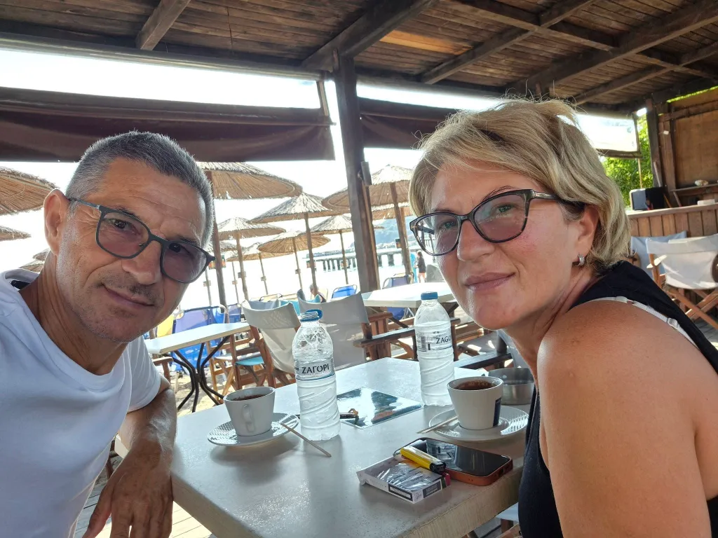 Svetlana Grkovic and Ljubisa Karovic sitting at a table with coffee and water bottles.
