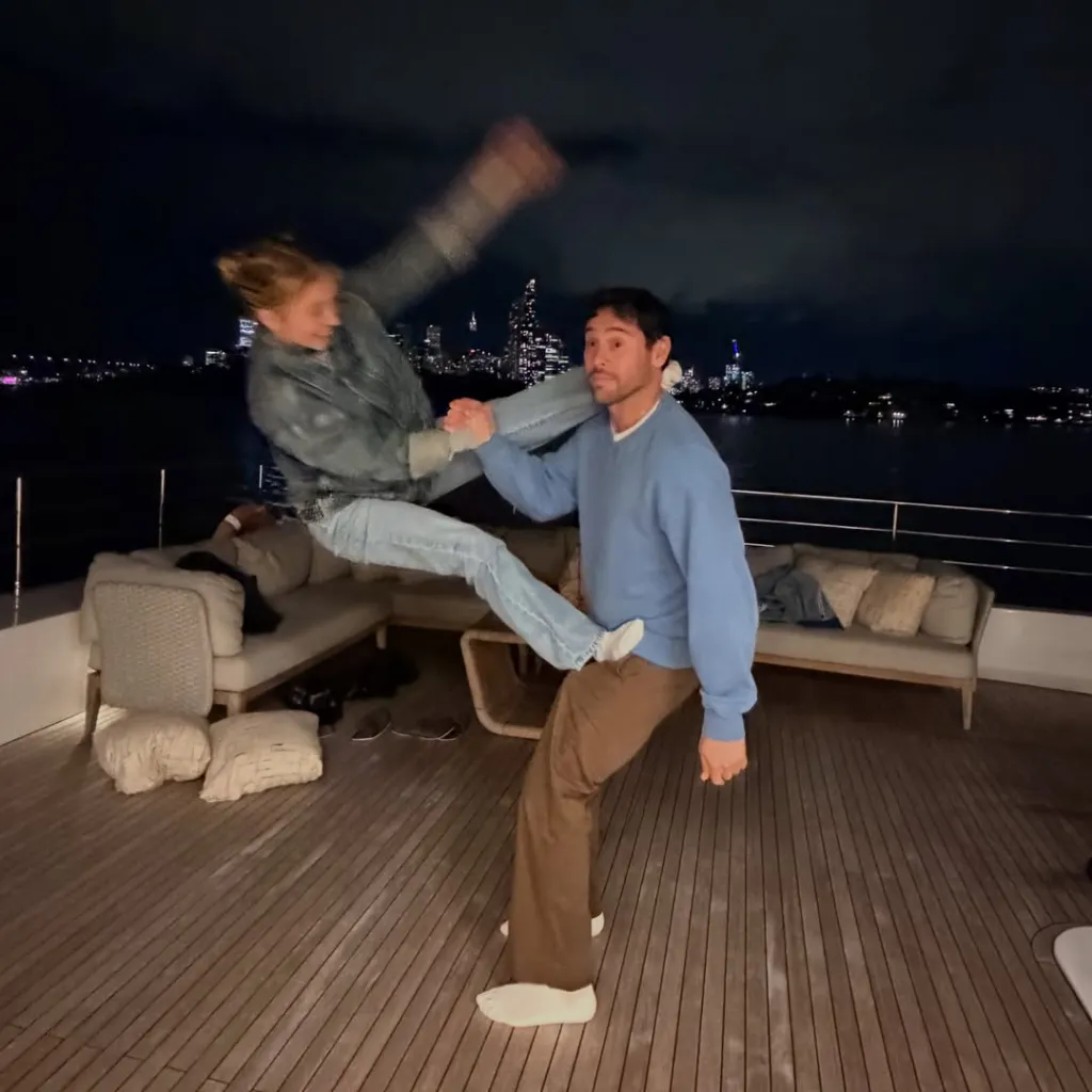 Sydney Sweeney kicking Scooter Braun in the shoulder while on a boat.