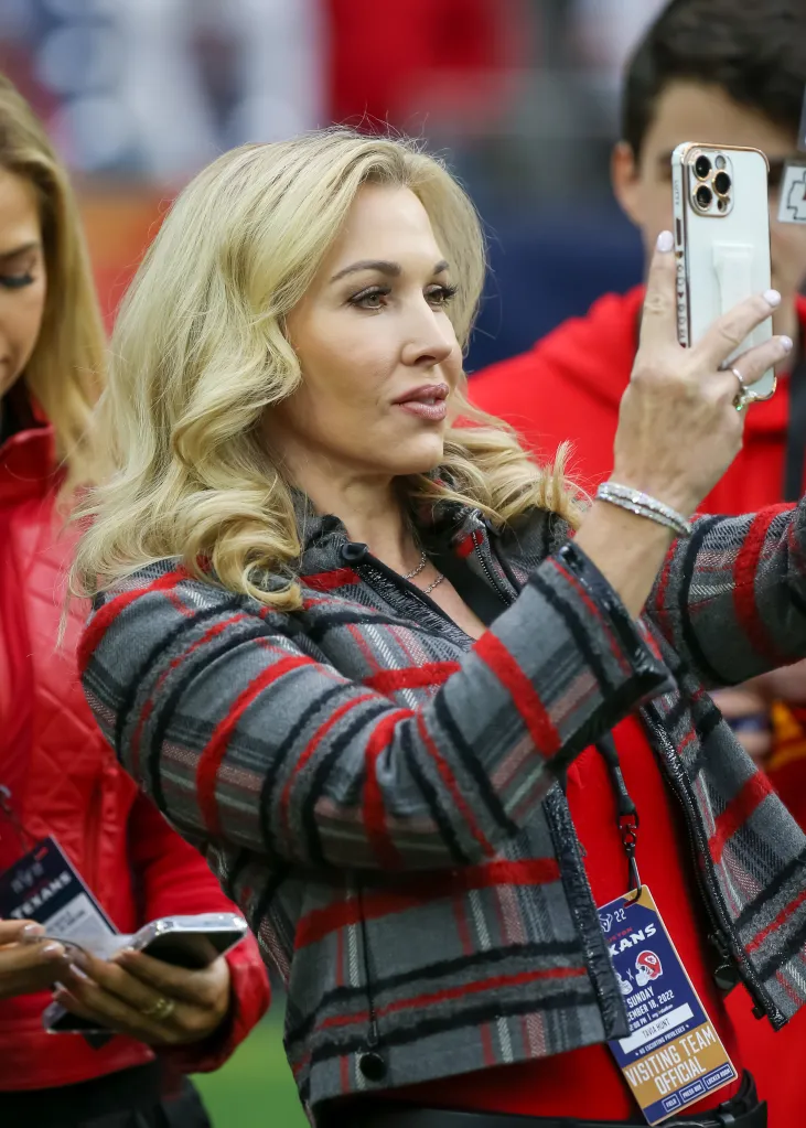Tavia Hunt, wife of Kansas City Chiefs CEO Clark Hunt, taking a selfie with fans during an NFL game.